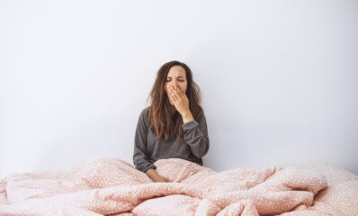 Woman in bed struggling to get to sleep - featured image to illustrate sleep disorders and MS