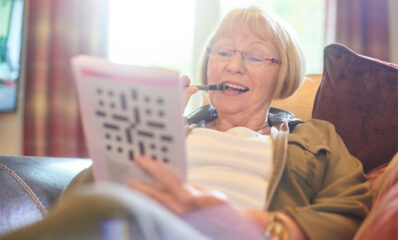 Woman doing a crossword, illustrating cognitive symptoms of multiple sclerosis