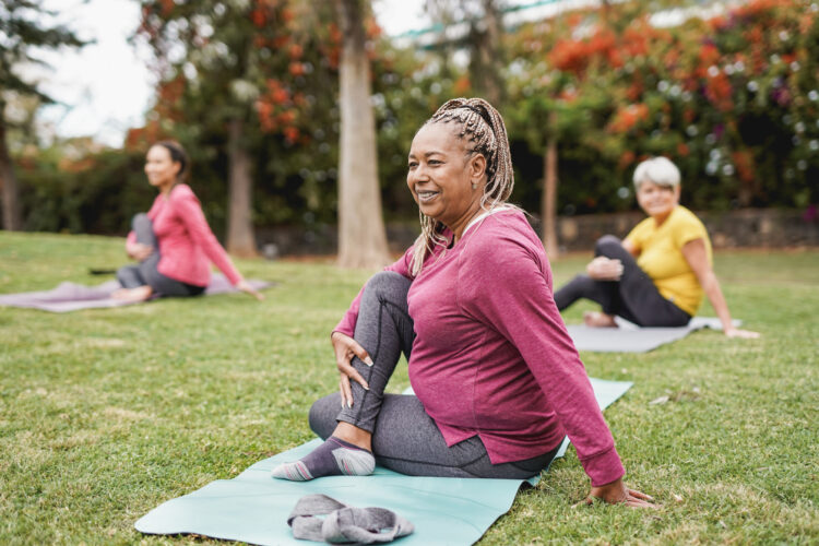 Women in a park practicing Pilates with relaxation improves MS symptoms