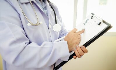 Doctor observing notes about multiple sclerosis and seizures