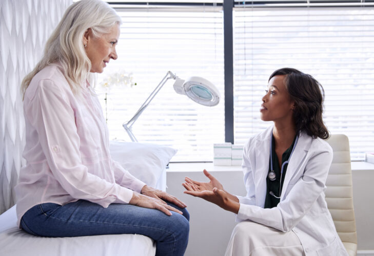 Woman in a consultation around what could be experienced before being diagnosed with MS - constipation, depression, or UTIs