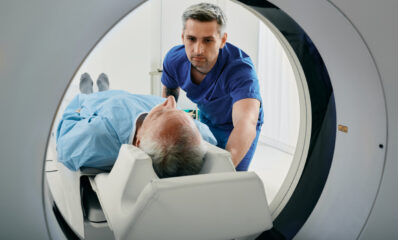 Senior man going into CT scanner, featured image for news article around how early brain changes in MS may predict progression