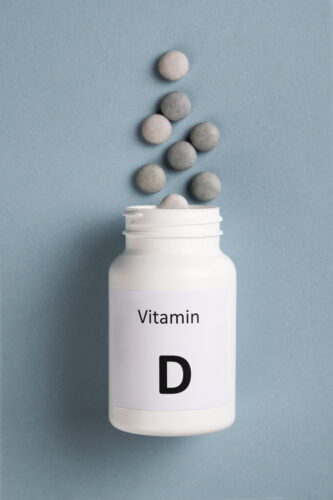 Pot of vitamin D tablets spilt out, featured image for a blog focused around high-does vitamin D has no effect on relapse rate