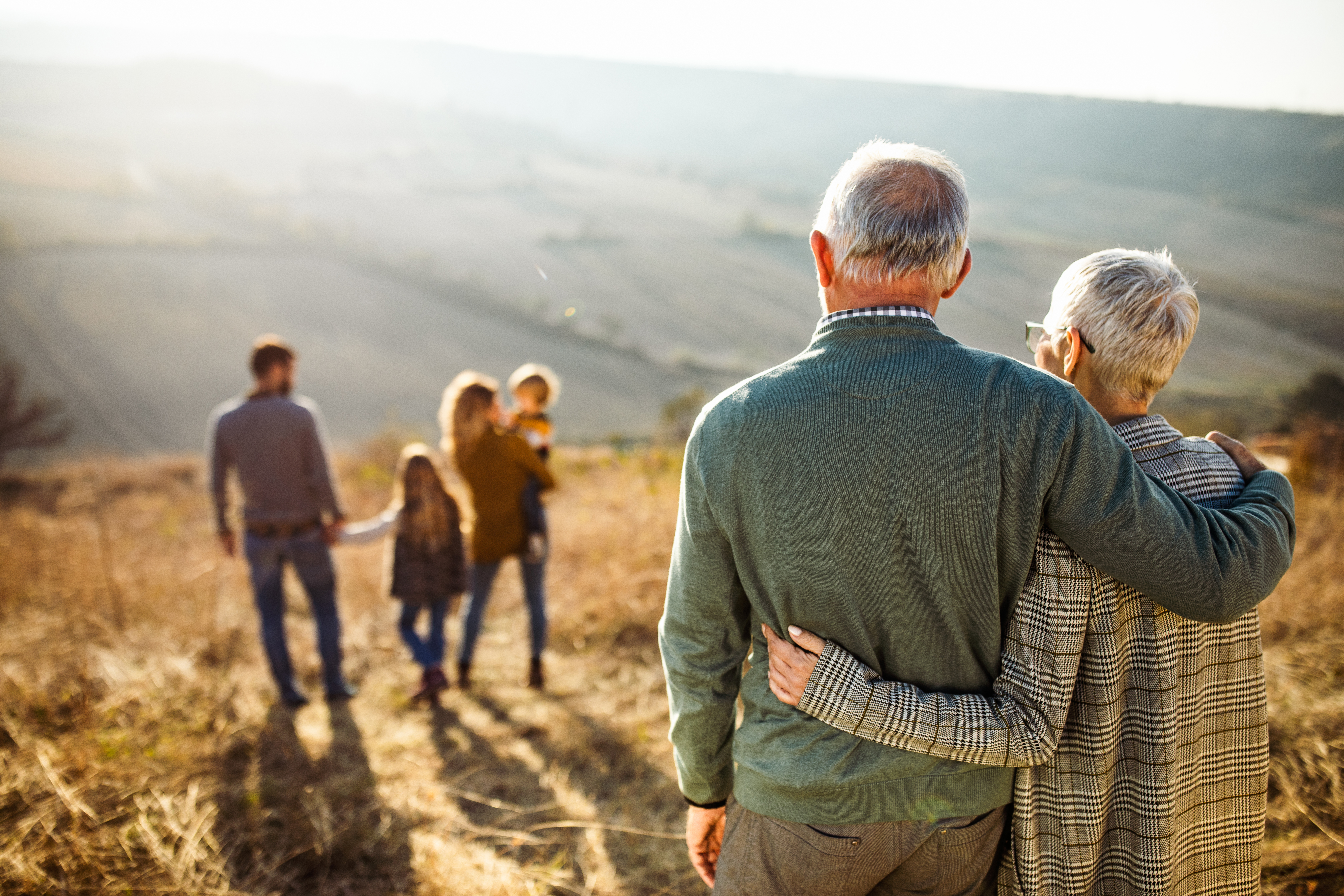 Older man and woman looking at their younger family.