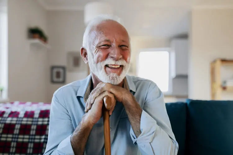 Image shows a happy man with a walking cane