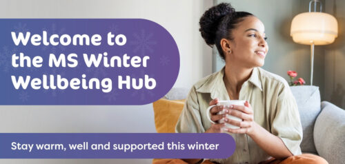 A person sitting comfortably on a sofa, holding a warm drink and smiling while looking out of the window. Text on the image reads, “Welcome to the Winter Wellbeing Hub. Stay warm, well and supported this winter.”