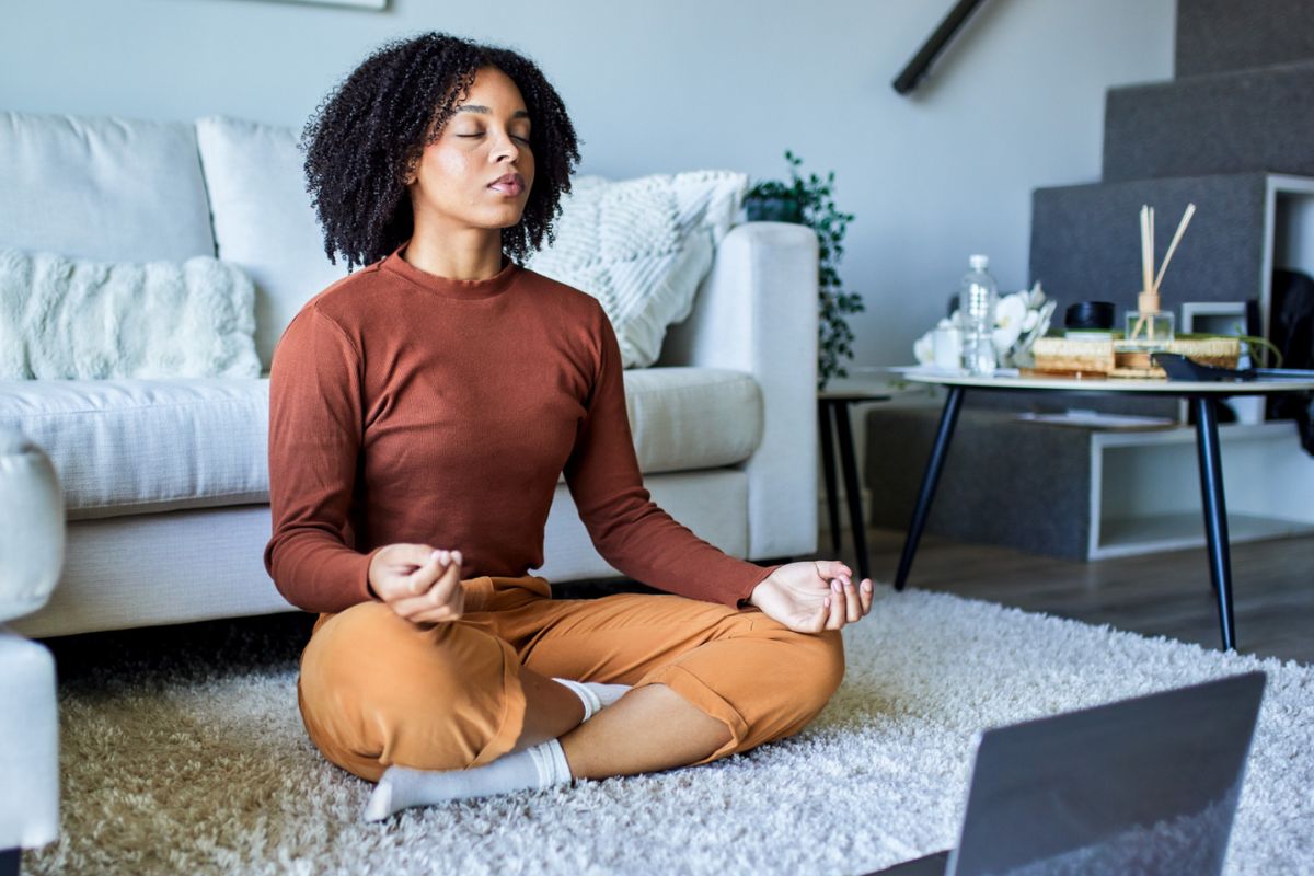 Young woman taking part in a guided meditation taster session from home