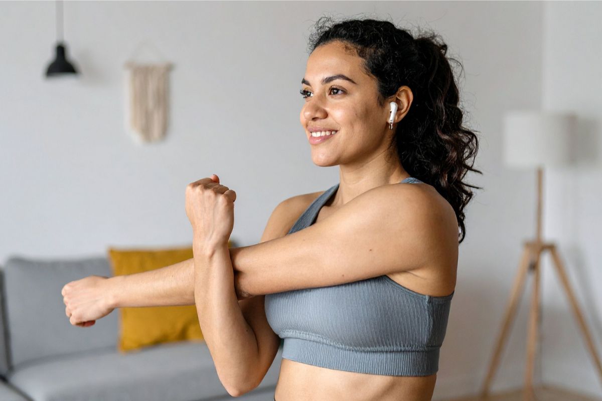 Young woman stretching at home, taking part in strength training for MS